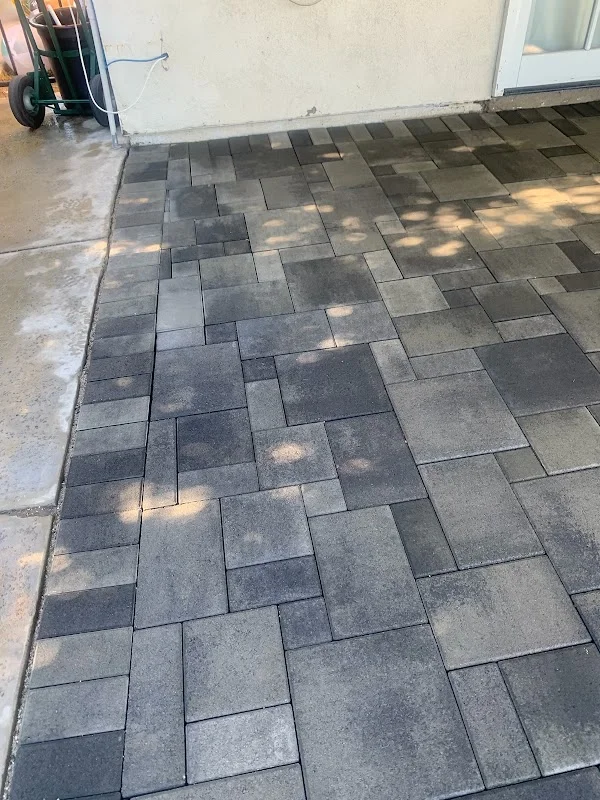 Charcoal and gray concrete permeable pavers installed in running bond pattern on residential patio